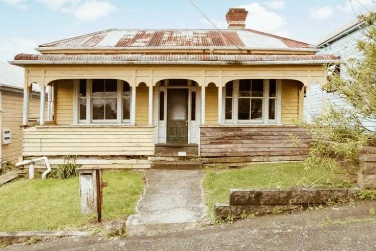 A classic New Zealand weatherboard villa with a rusted iron roof and timber porch